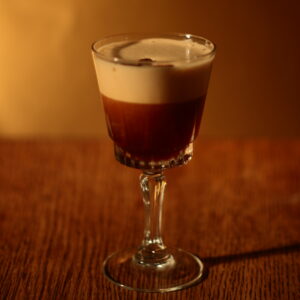 Espresso Martini in a stemmed cocktail glass with a thick foam layer and three coffee beans on top
